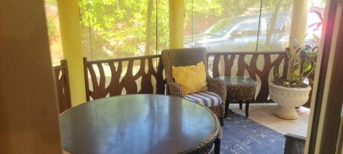una veranda con tavolo in vetro e sedia di Private Lodge, Cousin's Cove a Green Island