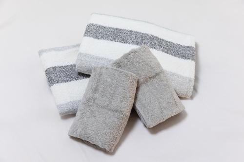 a group of three towels on a white background at SHIBUYA Bright Modern 40sqm Apartment FAMILY FRIENDLY!! in Tokyo
