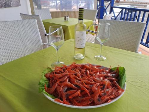 ein Teller Garnelen auf einem Tisch mit zwei Weingläsern in der Unterkunft Casa Velalatina in La Santa