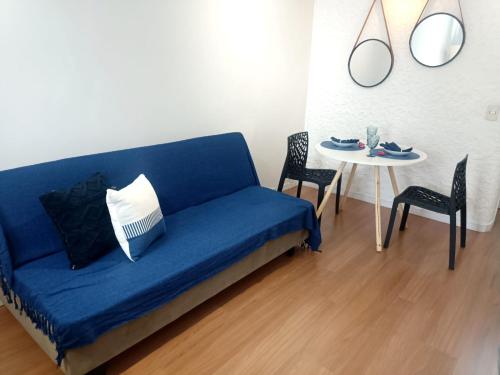 a blue couch in a living room with a table at Loft Blue - Av Rio Branco in Juiz de Fora