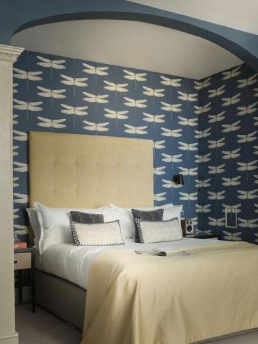 a bedroom with a bed with blue and white wallpaper at The Queensberry Hotel in Bath