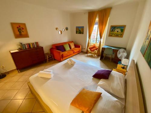 a bedroom with a large bed and a living room at Porta Romana - Bright Studio 350m from M3 in Milan