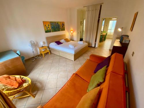 a bedroom with a bed and a couch in a room at Porta Romana - Bright Studio 350m from M3 in Milan