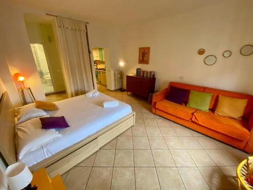 a bedroom with a large bed and an orange couch at Porta Romana - Bright Studio 350m from M3 in Milan