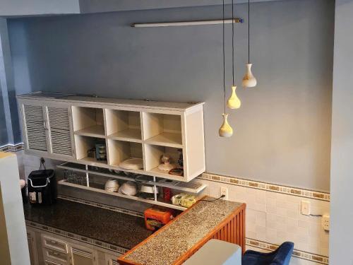 a kitchen with a counter and a cabinet with shelves at Vung Tau Villa mini sát biển - Gitico Homestay in Vung Tau