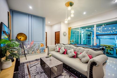 a living room with a white couch with red pillows at M4 Billion Pool Villa Cha-am in Cha Am