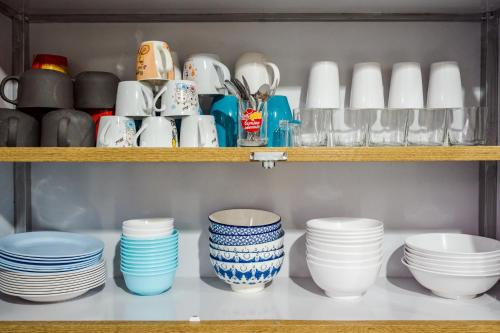 a shelf full of plates and cups and bowls at M4 Billion Pool Villa Cha-am in Cha Am