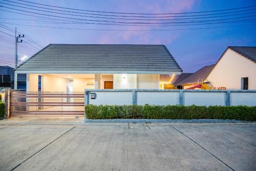 a white house with a fence in front of it at M4 Billion Pool Villa Cha-am in Cha Am