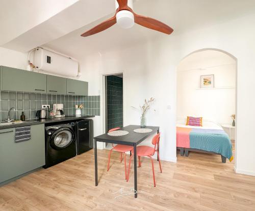 Il comprend une cuisine et une salle à manger avec une table et un ventilateur de plafond. dans l'établissement Le Nid Provençal - Vue Cathédrale - 300 metres du port, à Toulon