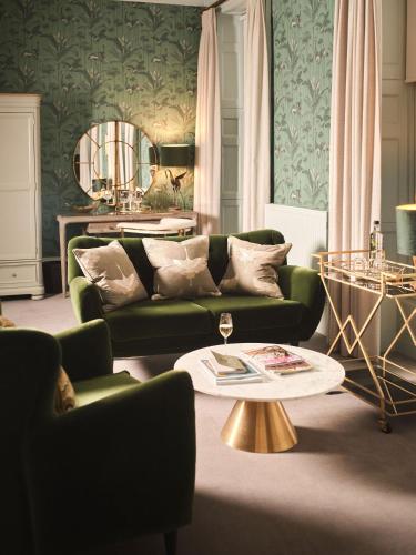 a living room with a green couch and a table at The Queensberry Hotel in Bath