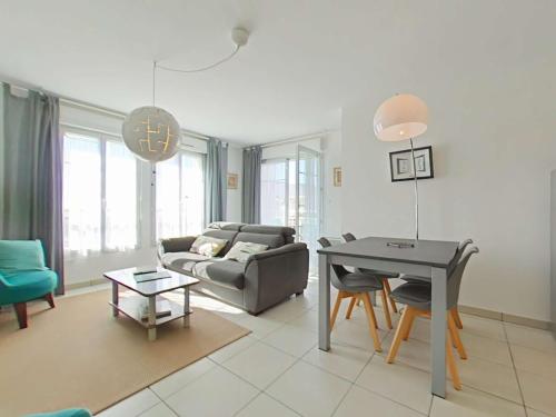 un salon avec un canapé et une table dans l'établissement Appartement 3 pièces avec balcon à 700m de la plage - 6 couchages, garage, classé 3 étoiles - FR-1-224-710, à Saint-Gilles-Croix-de-Vie
