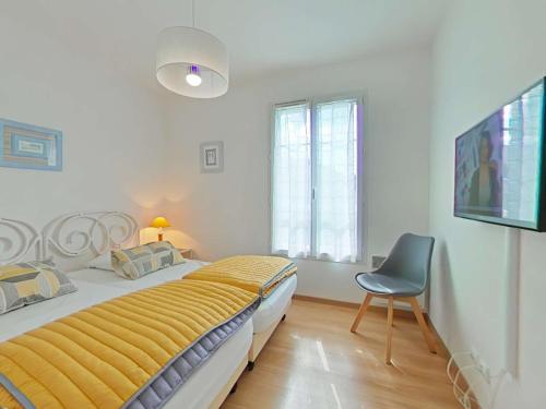 ein Schlafzimmer mit einem Bett und einem Stuhl darin in der Unterkunft Appartement 3 pièces avec balcon à 700m de la plage - 6 couchages, garage, classé 3 étoiles - FR-1-224-710 in Saint-Gilles-Croix-de-Vie