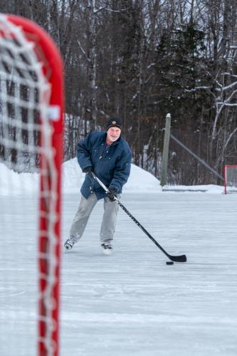 a man is playing hockey in the snow at Blue Water Acres in Huntsville