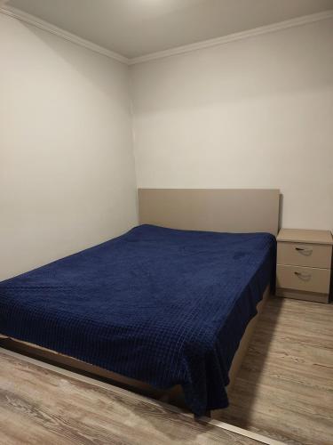 una camera da letto con un letto con una coperta blu di CaskadeSpot a Yerevan