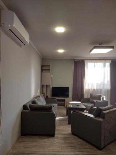 ein Wohnzimmer mit Sofas und einem Flachbildfernseher in der Unterkunft CaskadeSpot in Yerevan