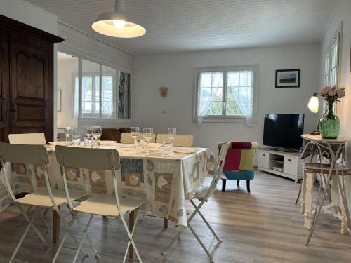 - une salle à manger avec une table et des verres à vin dans l'établissement Mais 4 pièces Oléron 6 couchages SAINT-PIERRE D'OLERON SPO000-099, à Saint-Pierre-dʼOléron