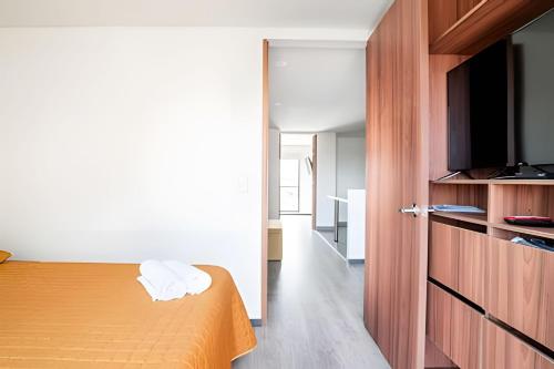a bedroom with a bed and a flat screen tv at Edificio Urban in Cajicá