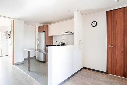 a kitchen with white walls and a wooden door at Edificio Urban in Cajicá
