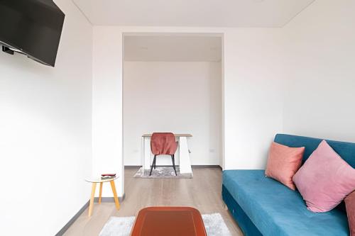 a living room with a blue couch and a table at Edificio Urban in Cajicá