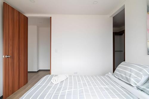 a bedroom with a white bed with a mouse on it at Edificio Urban in Cajicá
