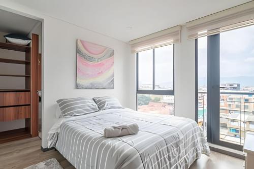 a white bedroom with a large bed and large windows at Edificio Urban in Cajicá
