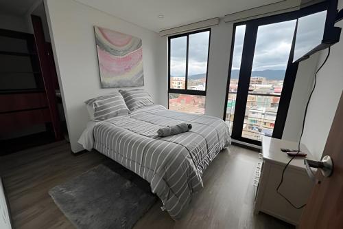 a bedroom with a bed with a large window at Edificio Urban in Cajicá