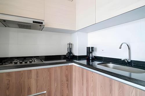 a kitchen with wooden cabinets and a sink at Edificio Urban in Cajicá