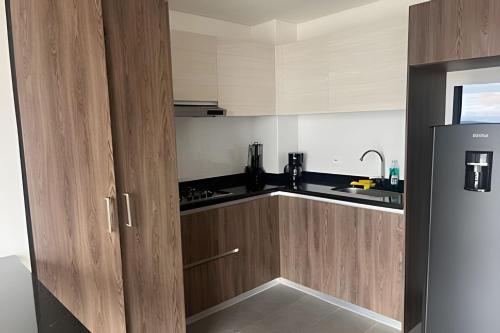 a kitchen with wooden cabinets and a refrigerator at Edificio Urban in Cajicá