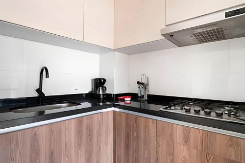 a kitchen with white cabinets and a black counter top at Edificio Urban in Cajicá