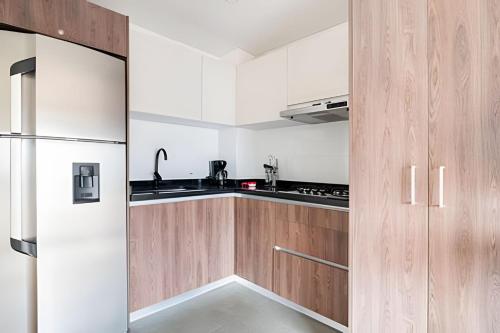 a kitchen with wooden cabinets and a refrigerator at Edificio Urban in Cajicá