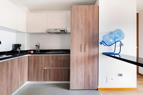 a kitchen with white cabinets and a blue chair on a shelf at Edificio Urban in Cajicá