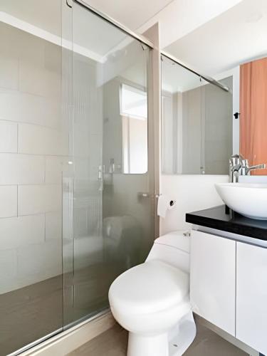 a white bathroom with a toilet and a sink at Edificio Urban in Cajicá