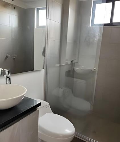 a bathroom with a toilet and a sink and a shower at Edificio Urban in Cajicá