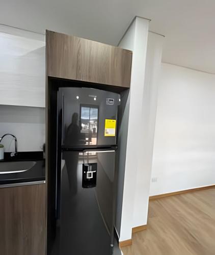 a black refrigerator in the corner of a room at Edificio Urban in Cajicá