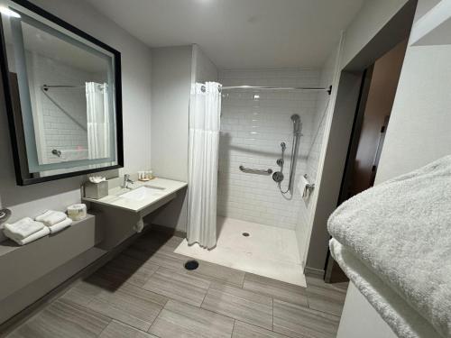 a bathroom with a shower and a sink at Surface Hotel OKC in Oklahoma City