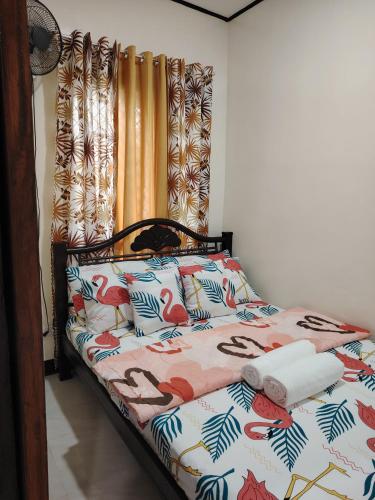 a bed with a colorful comforter with birds on it at Cozy Bella in Jalajala