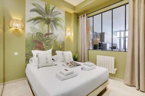 une chambre avec un grand lit blanc avec une fenêtre dans l'établissement Wonderful apartment - 1BR 5P - Sacré Cœur Ramey, à Paris