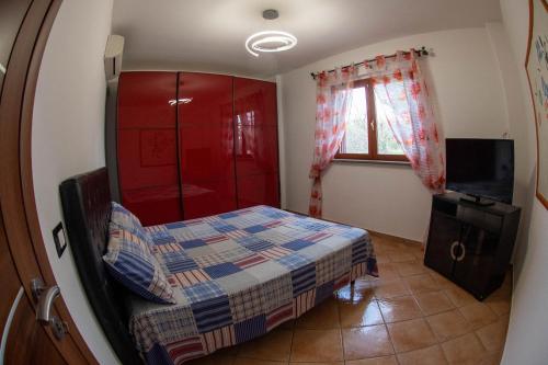 a bedroom with a bed and a tv and a window at Villa Anna in Genzano di Roma