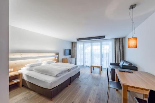 a hotel room with a bed and a desk at Sport- und Genusshotel Silvretta in Ischgl