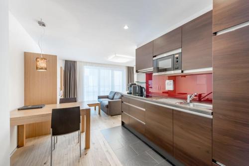 a kitchen with wooden cabinets and a dining room at Sport- und Genusshotel Silvretta in Ischgl