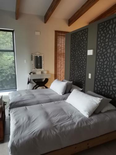a bedroom with two beds and a desk and a television at 69 Lagoon House in Marina Beach
