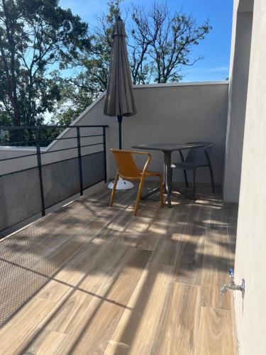 a balcony with a table and chairs and an umbrella at E casette in Oletta