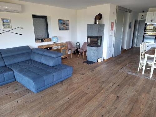 a living room with a blue couch and a table and a fireplace at Balaton Lake House in Balatonudvari