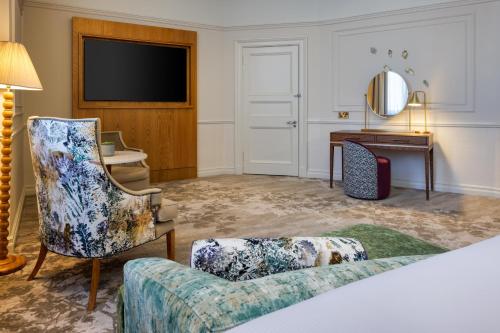 a living room with a couch and a television at The Caledonian Edinburgh, Curio Collection by Hilton in Edinburgh