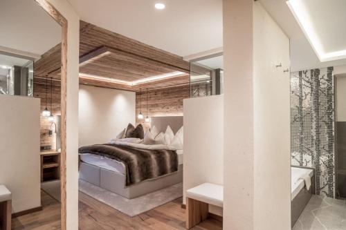 a bedroom with a large bed and a mirror at Sport- und Genusshotel Silvretta in Ischgl