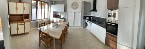 une cuisine avec une table et des chaises dans l'établissement maison campagne et mer 10 personnes, à Surville