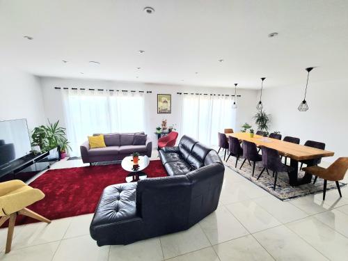 - un salon avec un canapé et une table à manger dans l'établissement Maison tout près d’Aurillac - Monts du Cantal, à Ytrac