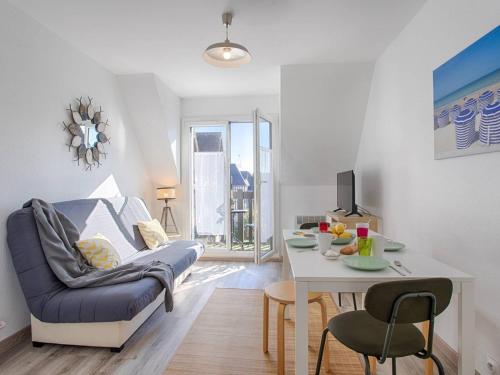 un salon avec un canapé et une table dans l'établissement Appartement à Deux Pas de la Plage de Cabourg, Balcon, WiFi, Parking Gratuit ! - FR-1-788-29, à Cabourg
