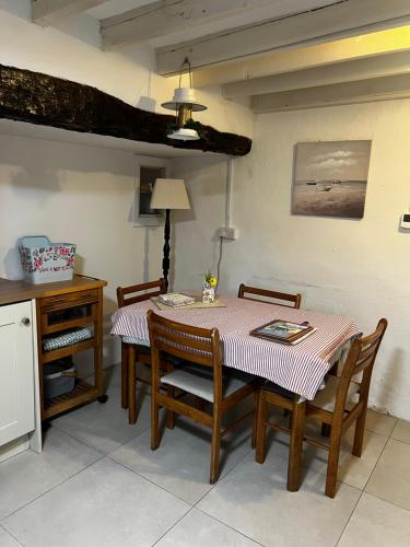 a dining room with a table and chairs and a table and a table at Bluebell Cottage in Kilmore Quay