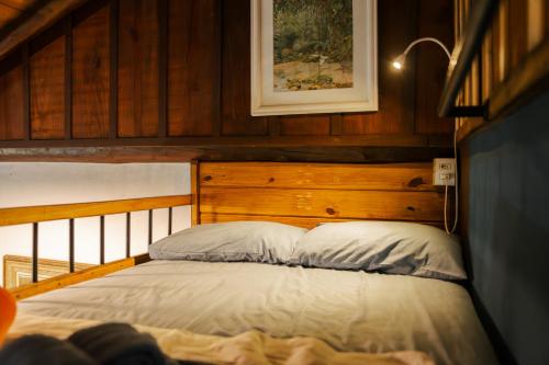 a bedroom with a bed with a wooden headboard at Atelier Arte Paraty Mirim in Paraty